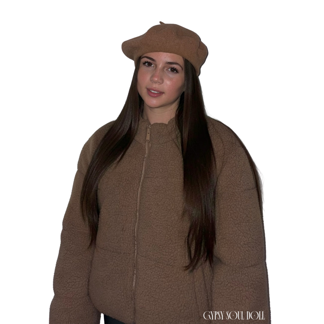 A model facing forward against a plain white background, wearing a cosy brown zip-up teddy puffer coat accessorised with a classic knitted light brown wool beret hat by Gypsy Soul Doll.