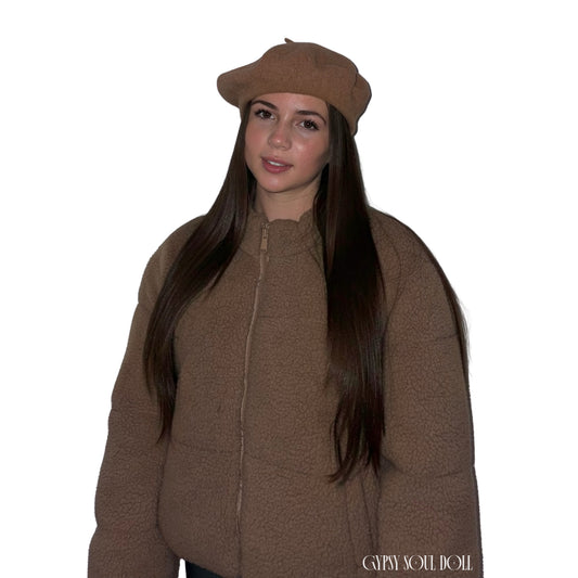A model facing forward against a plain white background, wearing a cosy brown zip-up teddy puffer coat accessorised with a classic knitted light brown wool beret hat by Gypsy Soul Doll.