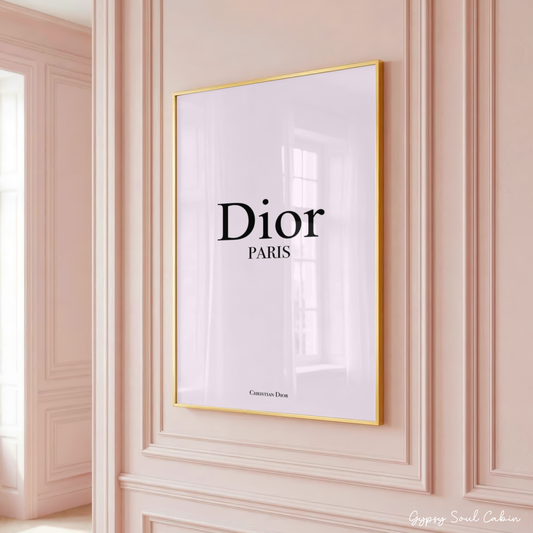 High-end Dior Paris typography art print in a gold frame hanging on a classic panelled pastel pink wall.
