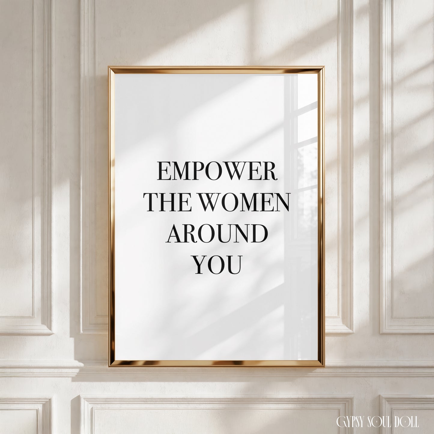 Empowering wall art with a motivational quote on a white background, featuring bold black text that reads empower the women around you.
