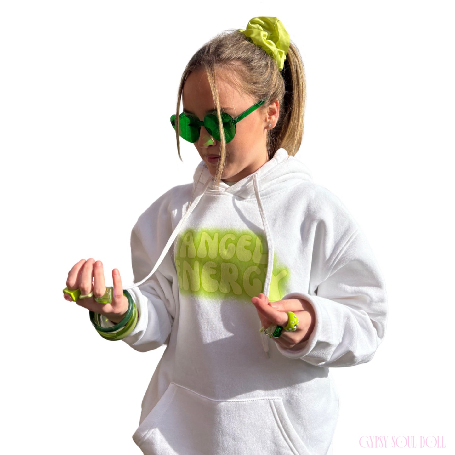 Model showcasing green heart-shaped glasses paired with matching green bangles, chunky rings, a hair scrunchie, and an Angel Energy hoodie by Gypsy Soul Doll.