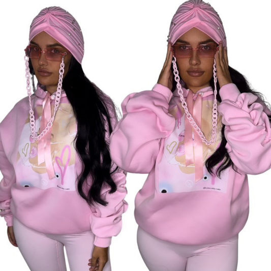 Collage showing front and detail angles of a model in a roomy, comfortable pink polyester hoodie featuring scrunched sleeves, ribbon ties, and original graphic art.