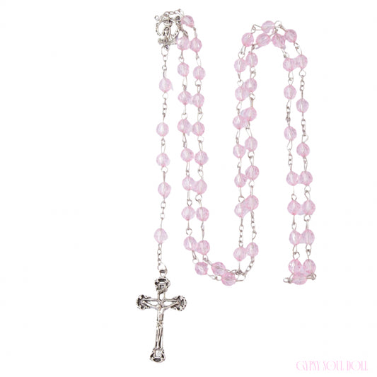 The Gypsy Soul Doll Sweetheart rosary beads feature coiled, transparent, faceted pink crystal beads linked on a silver chain with a crucifix pendant.