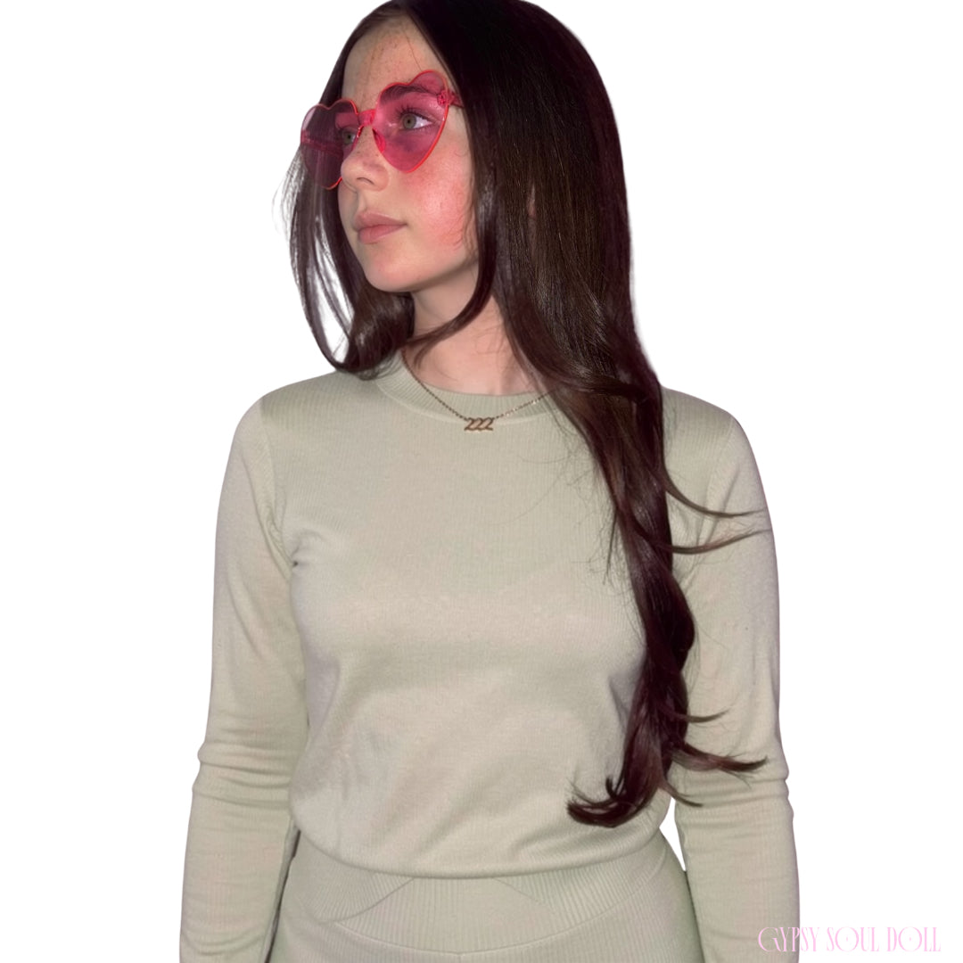 Model with long dark hair looking to the side while wearing a sage green top and the Gypsy Soul Doll dainty gold link chain necklace featuring a 222 angel number block charm.