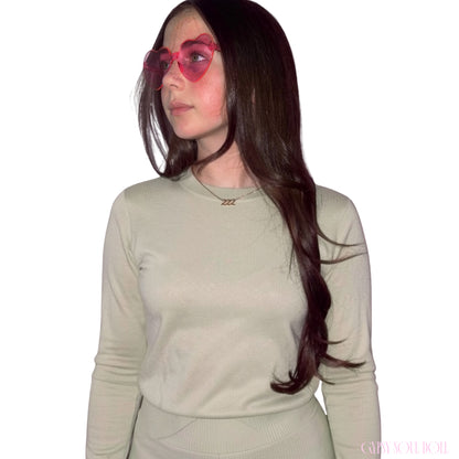 Model with long dark hair looking to the side while wearing a sage green top and the Gypsy Soul Doll dainty gold link chain necklace featuring a 222 angel number block charm.