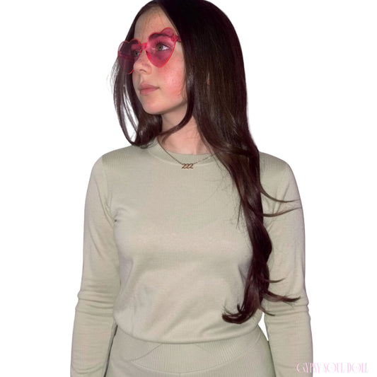 Model with long dark hair looking to the side while wearing a sage green top and the Gypsy Soul Doll dainty gold link chain necklace featuring a 222 angel number block charm.