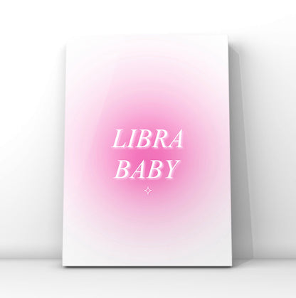 A vertical canvas art print featuring a pink gradient background with the words 'LIBRA BABY' in white serif lettering, displayed against a clean white wall.