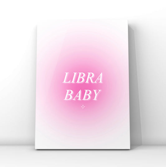 A vertical canvas art print featuring a pink gradient background with the words 'LIBRA BABY' in white serif lettering, displayed against a clean white wall.