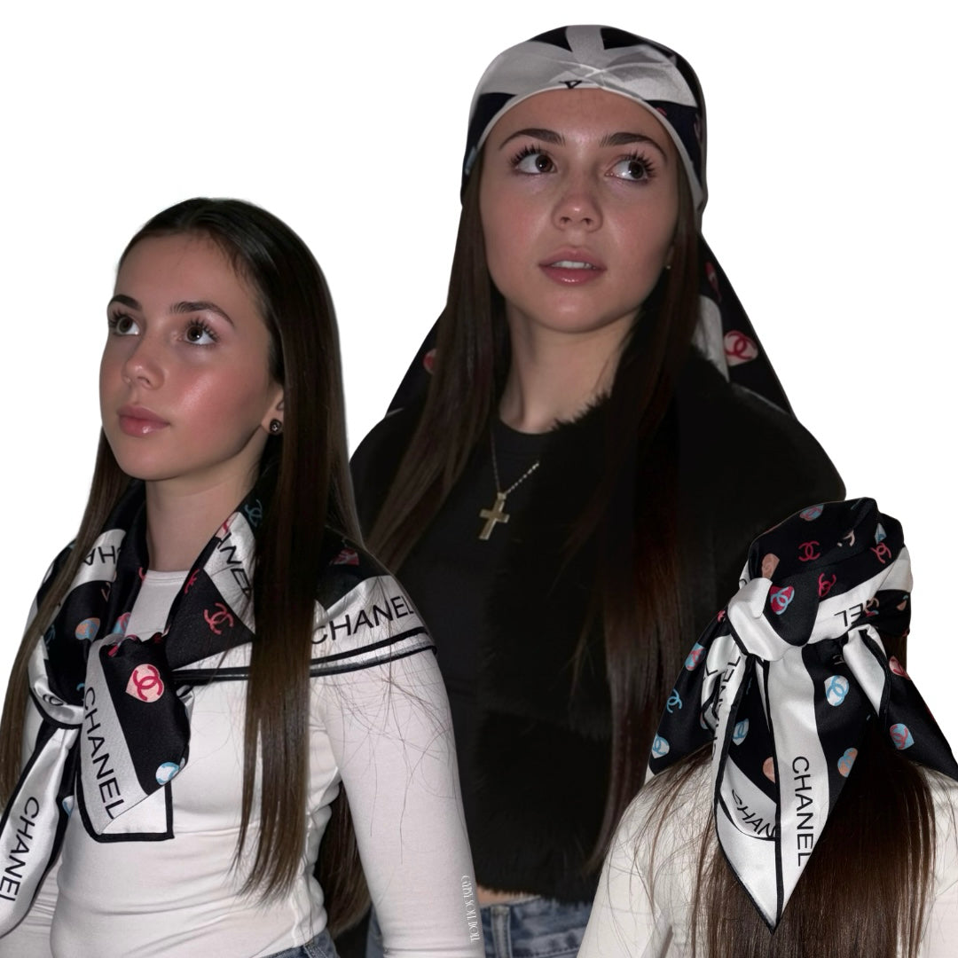Three views of a model styling a black and white branded luxury satin scarf worn as a shoulder drape, a head wrap bandana, and a tied boho hair bow.