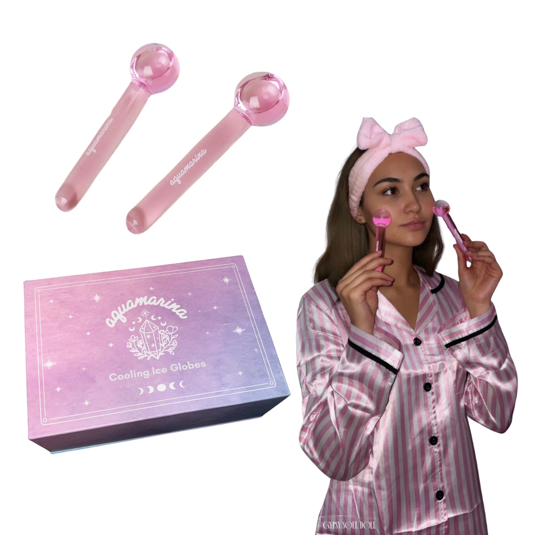 An ombre purple and pink celestial gift box labelled Cooling Ice Globes next to a pair of bubblegum pink glass facial massage cryotherapy tools and a model using them on her face.