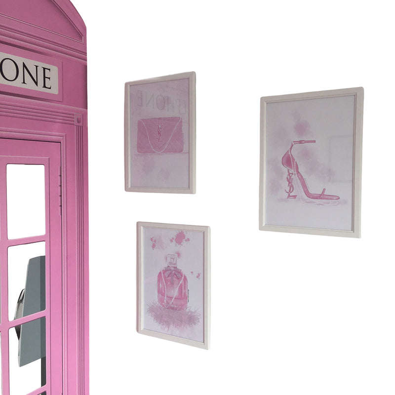 Pink telephone booth with framed pink fashion illustrations on a white background