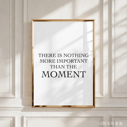 A black and white quote print with the text 'There is nothing more important than this moment' on a white background.