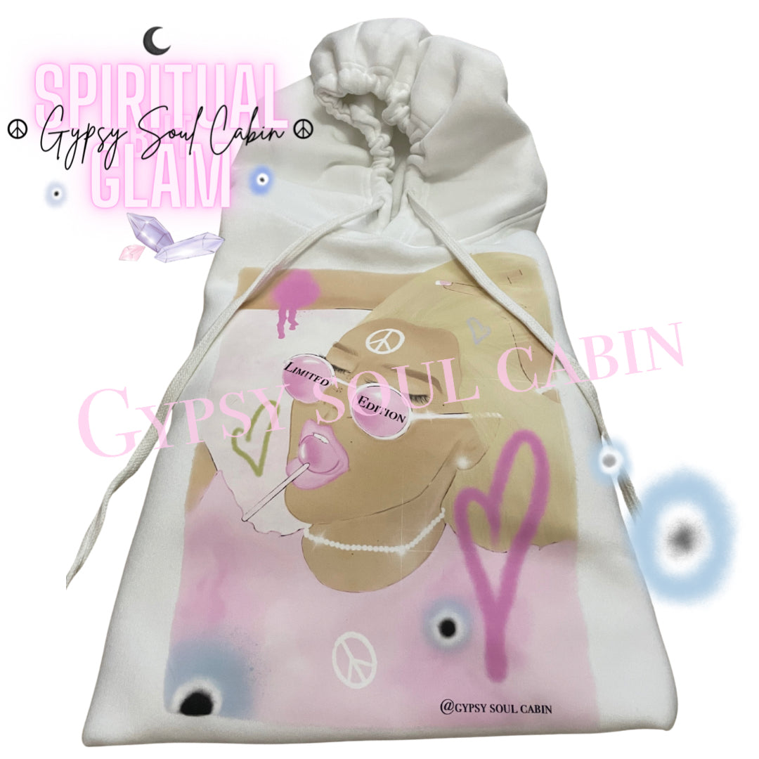 White oversized hoodie featuring a colourful, artistic graphic of a woman with sunglasses, surrounded by pink and purple hearts, peace symbols, and the text "Gypsy Soul Cabin" and "Spiritual Glam," with drawstrings and a front pocket.