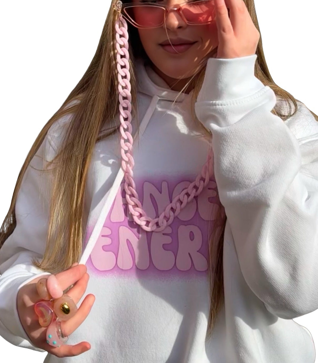 A young woman with long blonde hair wearing a white hoodie with a pink gradient 'ANGEL ENERGY' graphic and a chunky pink chain lanyard attached to Pink fashion glasses. She is also wearing 6 retro chunky rings posing against a solid white background.