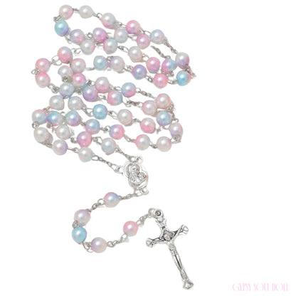 A rosary necklace featuring iridescent pastel pearls in pink, blue, and white, connected by silver-tone links with a silver-tone crucifix and centerpiece, shown on a plain white background.