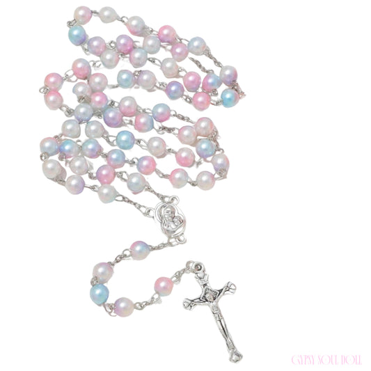 A rosary necklace featuring iridescent pastel pearls in pink, blue, and white, connected by silver-tone links with a silver-tone crucifix and centerpiece, shown on a plain white background.
