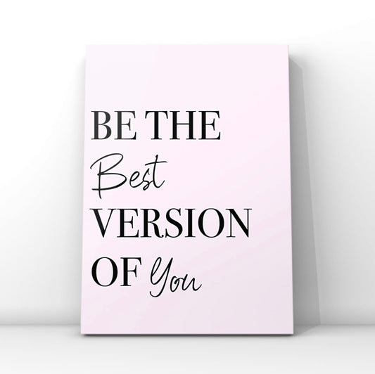 Minimalist pink affirmation print reading Be The Best Version Of You in a combination of crisp black serif and cursive script fonts, leaning against a clean white wall backdrop.
