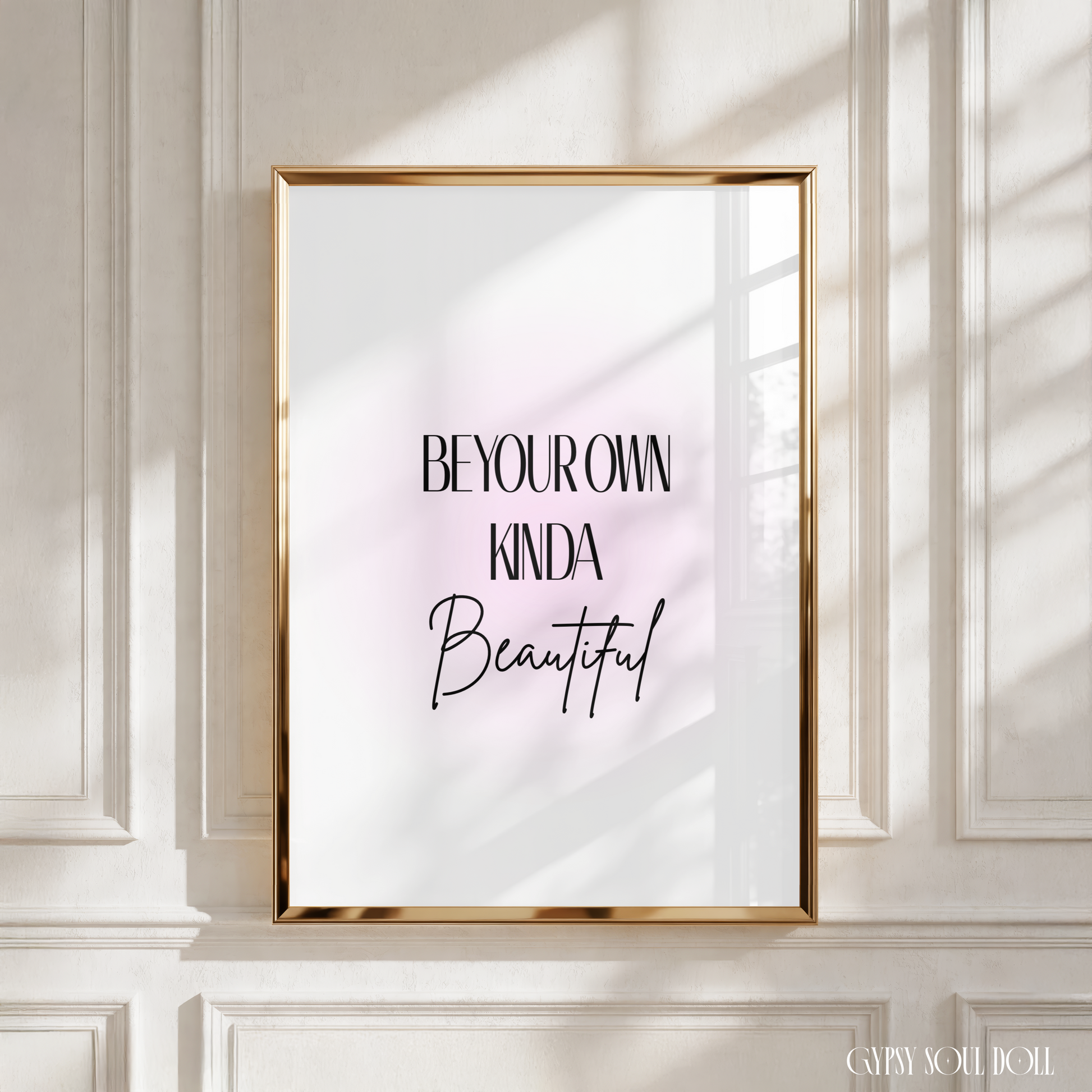 Sleek black typography motivational print displaying the text Be Your Own Kinda Beautiful centred over a soft blush pink aura gradient background.