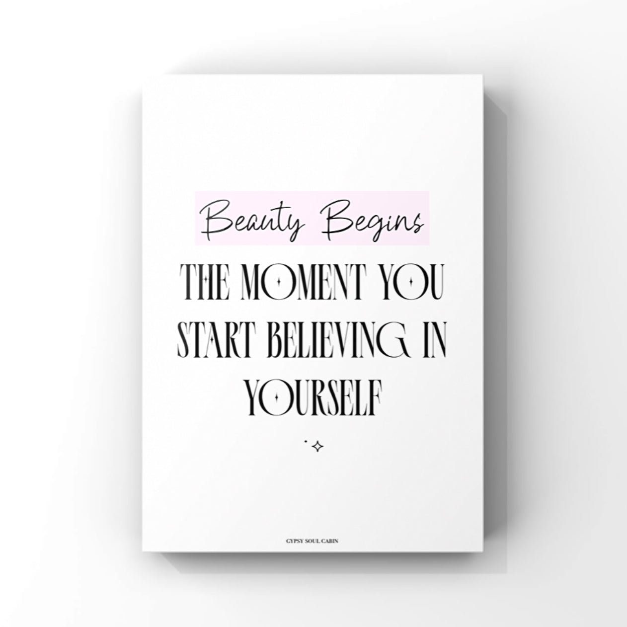 Mindset affirmation quote wall art print featuring the text Beauty Begins highlighted in a pink block above bold black lettering that reads The Moment You Start Believing In Yourself.
