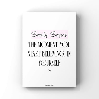 Mindset affirmation quote wall art print featuring the text Beauty Begins highlighted in a pink block above bold black lettering that reads The Moment You Start Believing In Yourself.