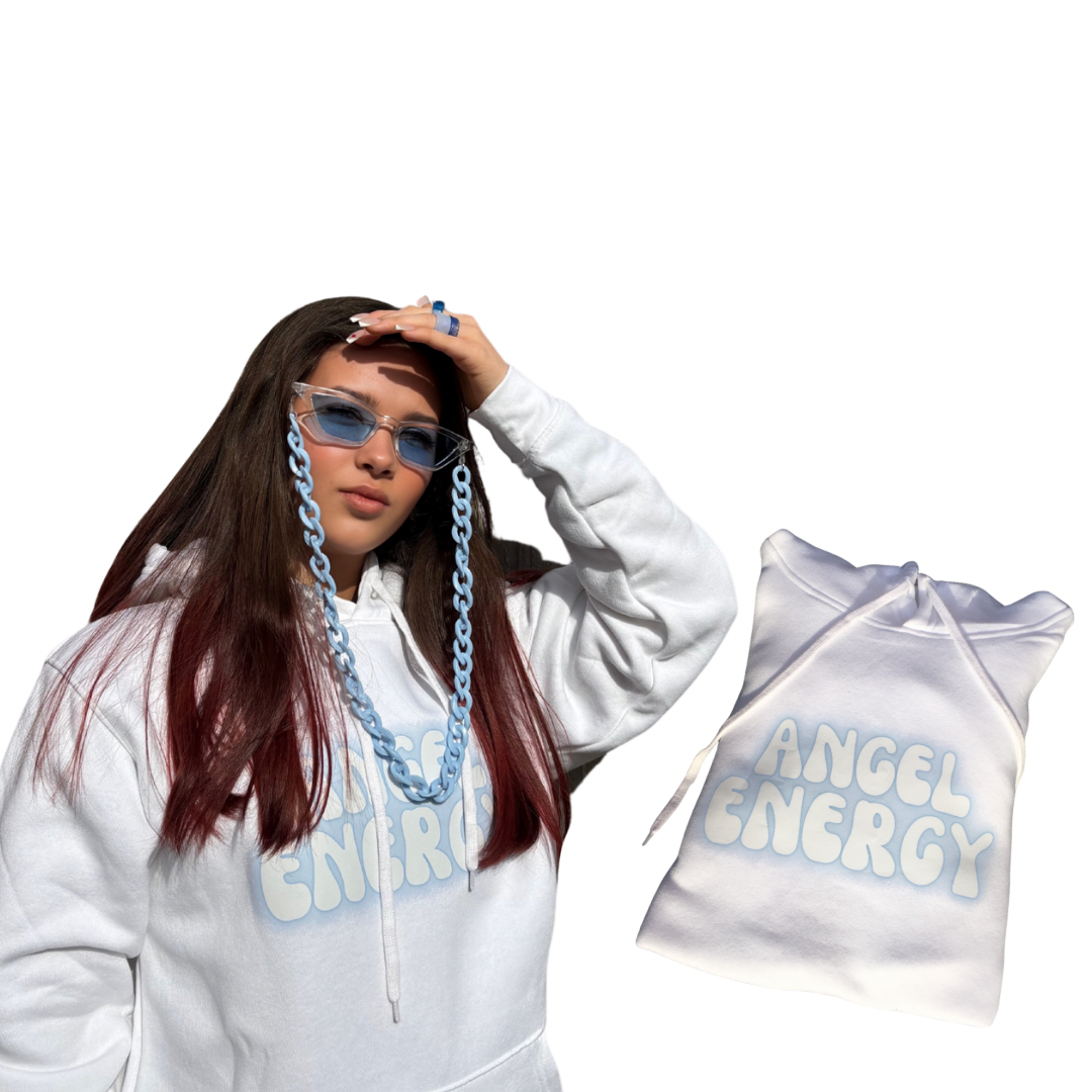 A young model wearing a white hoodie with a light blue gradient 'ANGEL ENERGY' graphic on the front, paired with a chunky light blue chain lanyard and blue-tinted fashion glasses. A matching white hoodie is shown floating to the right against a solid white background.