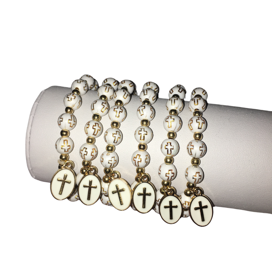 Six white beaded rosaries with gold-tone metal accents and oval cross pendants, arranged on a white cylindrical display stand against a white background.