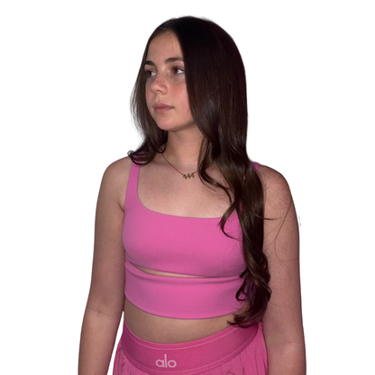 Model with long wavy brown hair looking to the side while wearing a bright pink top and the Gypsy Soul Doll dainty gold link chain necklace featuring a 444 angel number block charm.