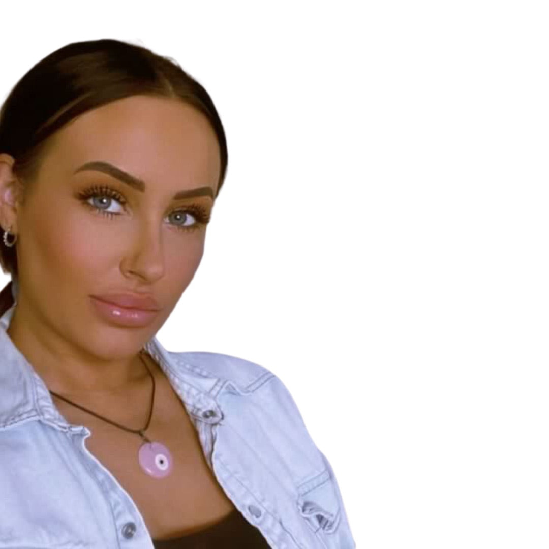 Close-up of a woman with glam makeup wearing a light denim shirt and the soft pastel pink glass evil eye cord necklace.