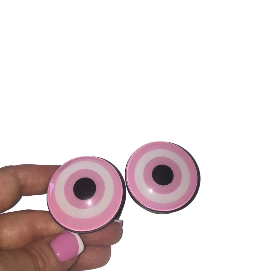 Two round pink and white spiritual evil eye phone grip sockets showing the expandable black base on a pure white background.
