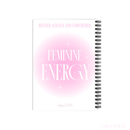 A back cover mockup of a Gypsy Soul Doll manifestation journal featuring a soft pink aura gradient centre with white sparkle stars and tall editorial typography reading Feminine Energy and Blessed Aligned and Unbothered at the top with a signature logo footer at the bottom centred over a white backdrop.