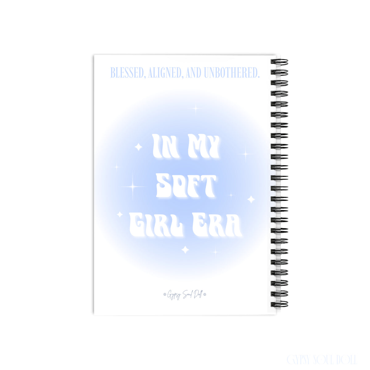 A white spiral notebook with a light blue and white graphic design on the cover. The cover features the text 'BLESSED, ALIGNED, UNBOTHERED and In My Soft Girl Era by Gypsy Soul Doll.