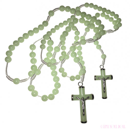 A light green beaded rosary necklace with two matching cross pendants featuring silver-tone crucifix details, displayed on a plain white background.
