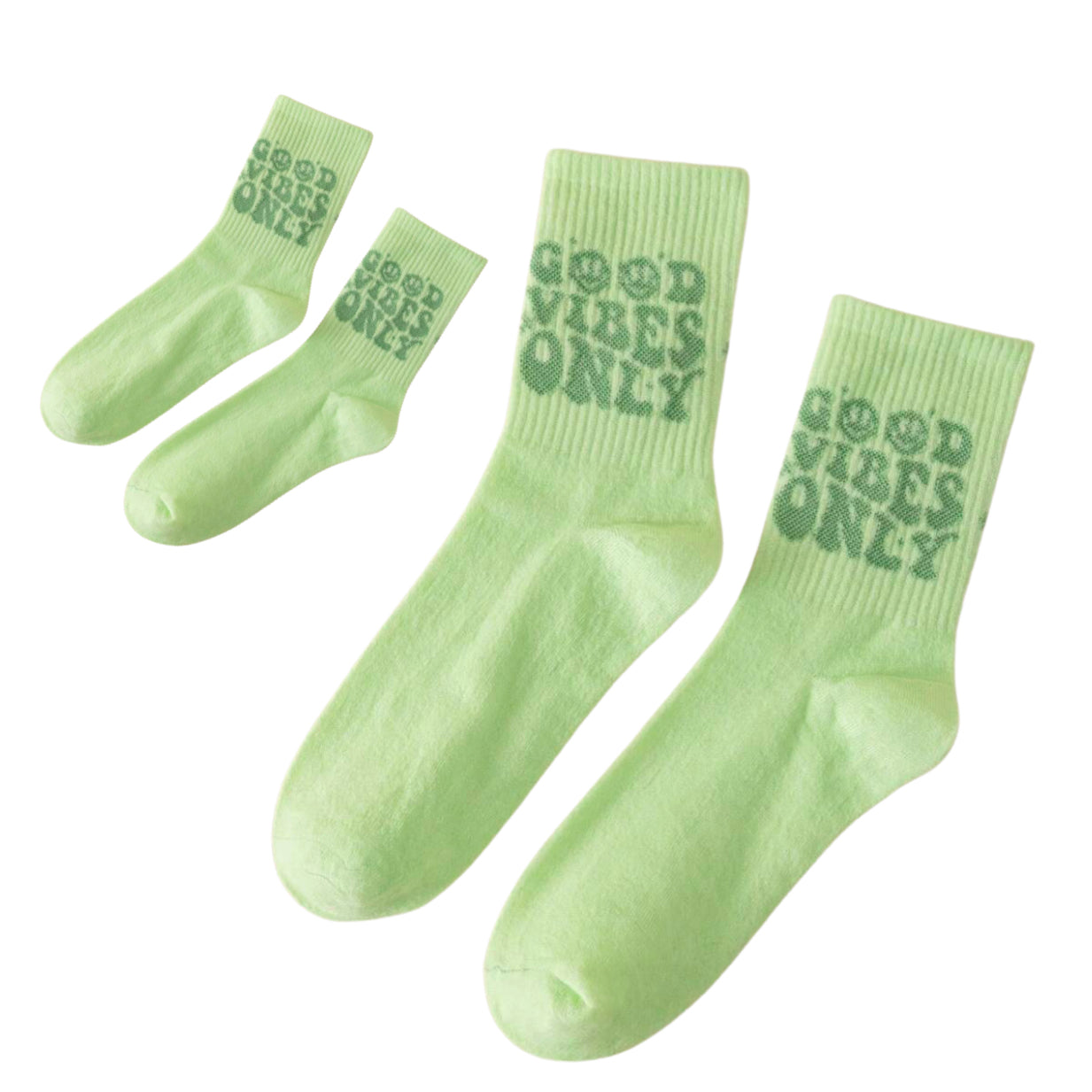 Pair of aesthetic pastel green crew socks featuring a retro wavy dark green text print that reads Good Vibes Only with smiley faces.
