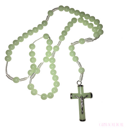 A light green beaded rosary necklace with a matching cross pendant featuring a silver crucifix, displayed on a clean white background.