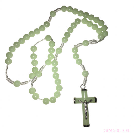 A light green beaded rosary necklace with a matching cross pendant featuring a silver crucifix, displayed on a clean white background.