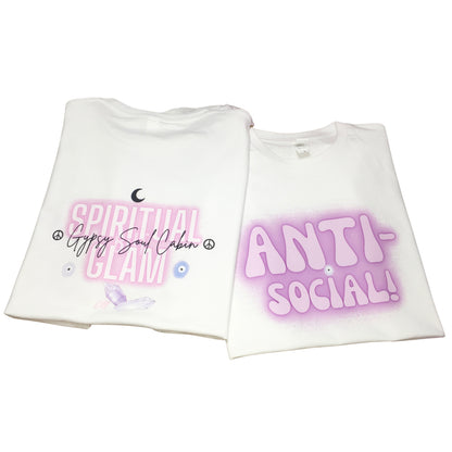Two folded white graphic t-shirts side by side displaying the original script logo print on the back and the fuzzy Anti-Social airbrush design on the front.