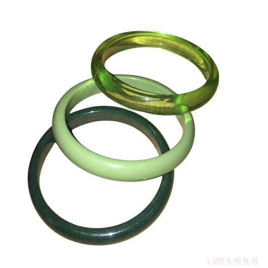 A stacked trio of Gypsy Soul Doll lime green acrylic bangle bracelets featuring a translucent neon lime band, a solid pastel sage ring, and a deep glossy forest green style against a plain white background.