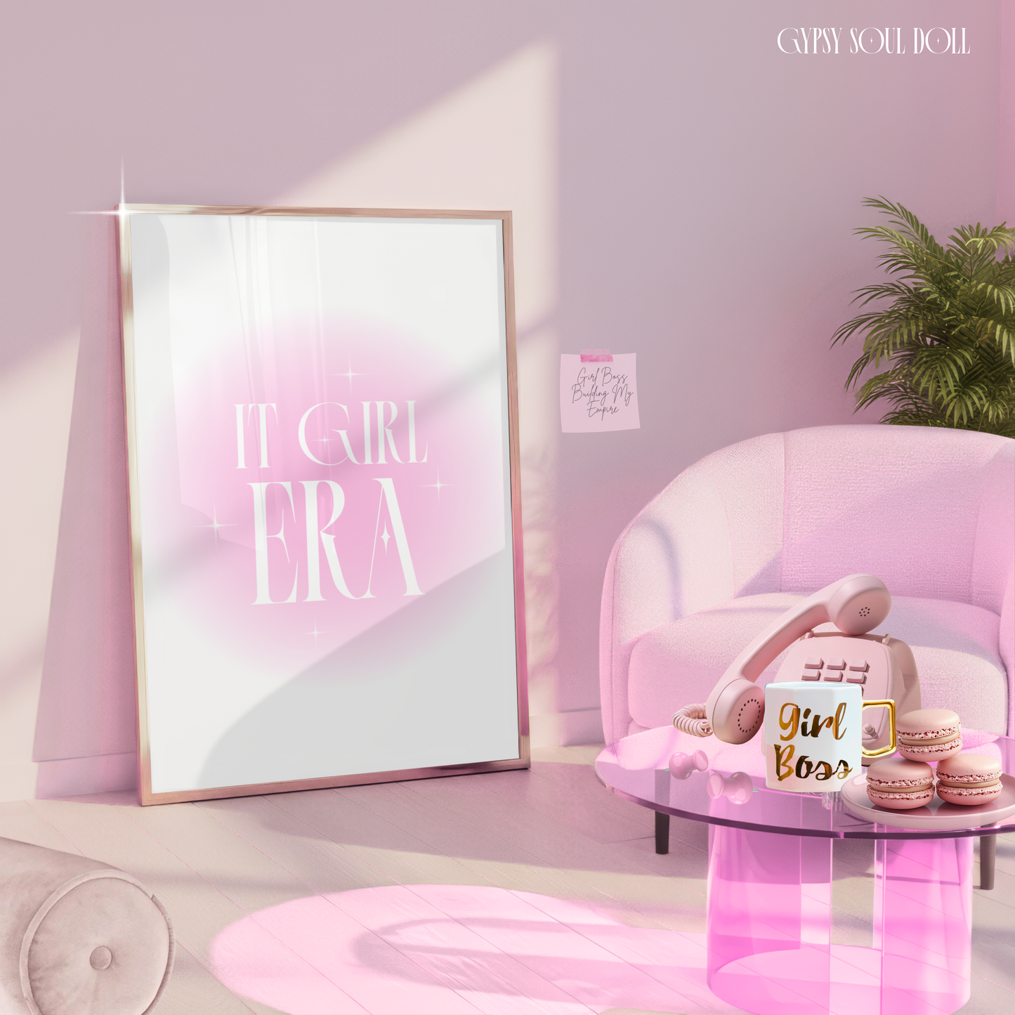 It Girl Era pink aura gradient typography print styled in a gold frame leaning against a wall in a luxury pink studio room featuring a chic armchair, a glass coffee table with a retro phone, and a Girl Boss mug.