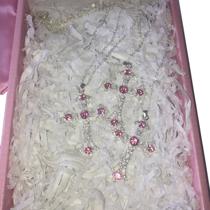 silver-toned cross necklace with pink rhinestones, displayed inside an open pink gift box.