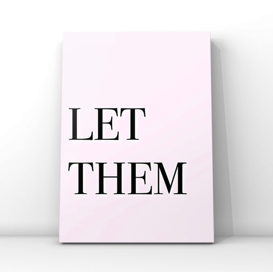 High-impact minimalist pink art print reading "Let Them" in a bold black serif font, leaning against a crisp white gallery wall.