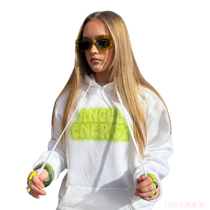 Front view of a model in a white festival graphic hoodie featuring lime green bubble text across the chest, styled with green-tinted fashion glasses and matching accessories.