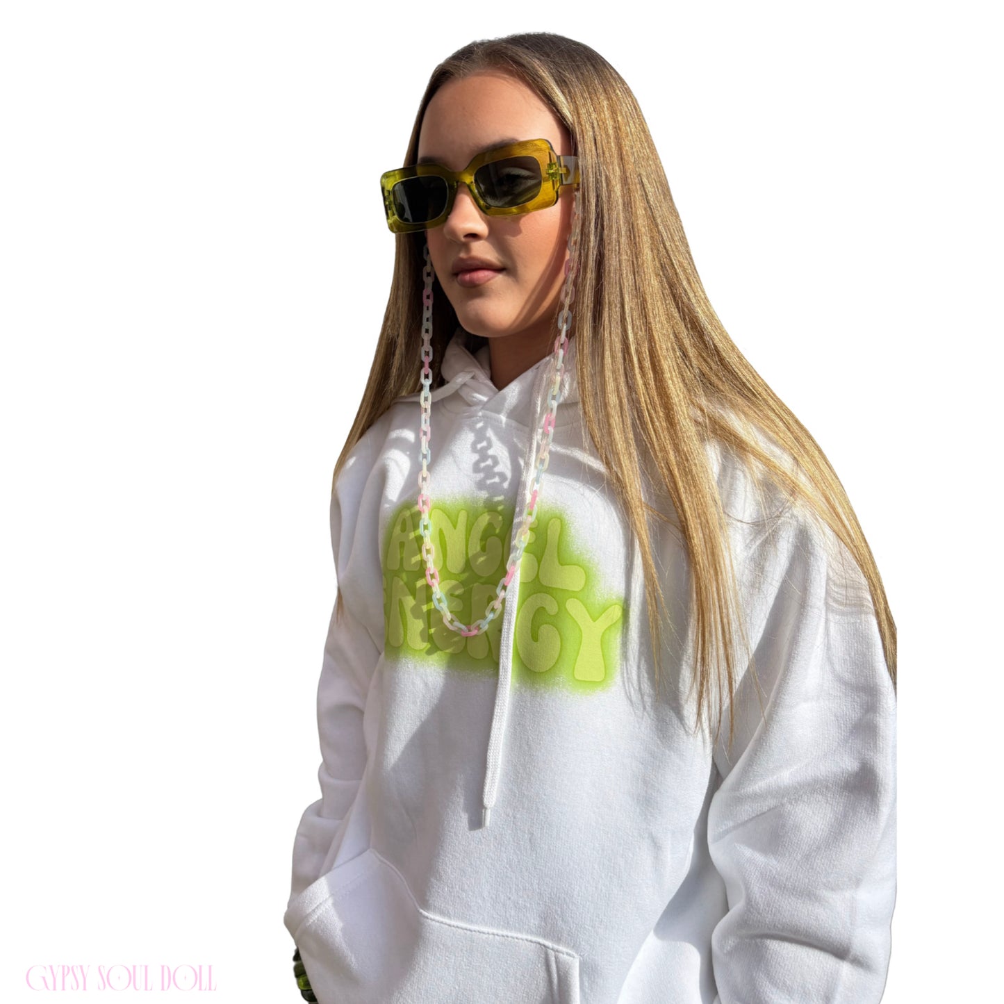 Three-quarter side view of a model modelling a white oversized hoodie with a vibrant green front text layout, showcasing long blonde hair and festival sunglasses with a lanyard attached.
