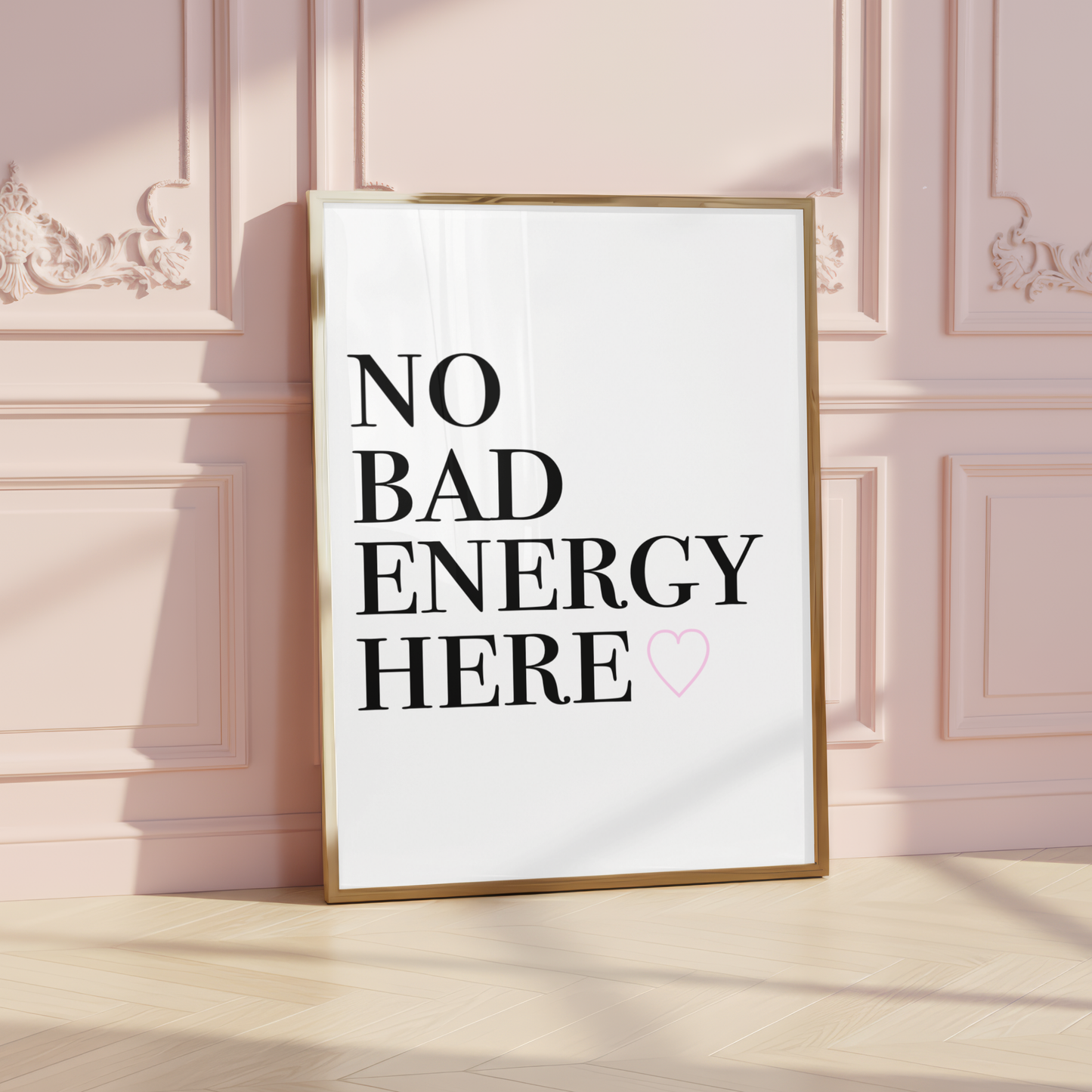 Minimalist A4 typographic wall art print featuring bold black stacked serif text reading NO BAD ENERGY HERE, paired with a small centred soft pink outline heart graphic.