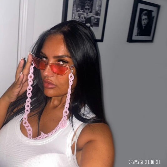 Model showcasing the Gypsy Soul Doll Saint Tropez translucent pink cat eye sunglasses with a matching thick pastel pink acrylic link lanyard strap chain against a plain white background.