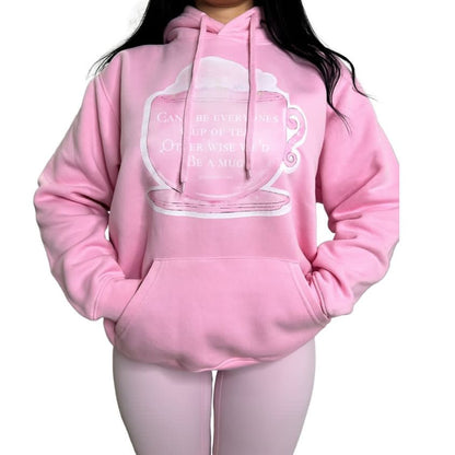 Front view of a model styling a roomy pink cotton oversized pullover hoodie featuring a front kangaroo pocket and central white graphic illustration.