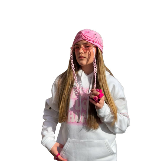 Front view of a model wearing a white oversized graphic hoodie that reads peace love & humble paired with a pink bohemian head wrap and pink fashion glasses. 