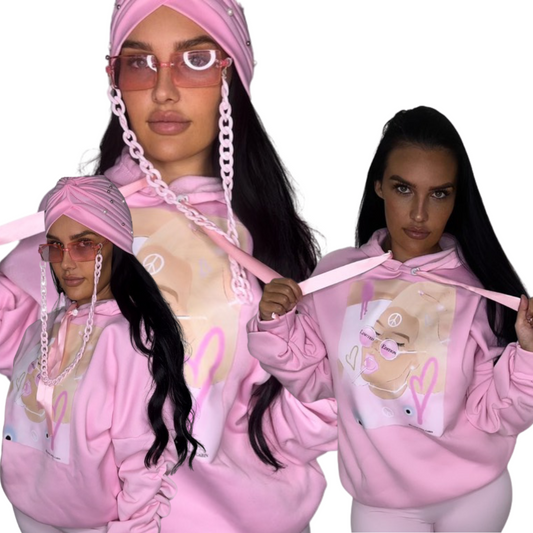 Collage showing front and detail angles of a model in a roomy, comfortable pink polyester hoodie featuring scrunched sleeves, ribbon ties, and original graphic art.