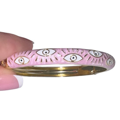 Front view of the Gypsy Soul Doll pink enamel evil eye bangle showcasing the repeating cosmic evil eye pattern with raised gold eyelashes and detailing.