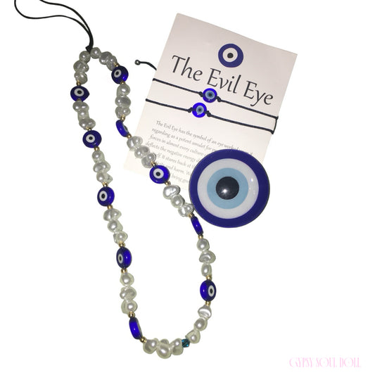 A Gypsy Soul Doll cobalt blue evil eye bundle featuring a glass disk amulet, a freshwater-style pearl beaded lanyard strap with eye beads, and a pair of cord slide bracelets on an explanatory backing card.