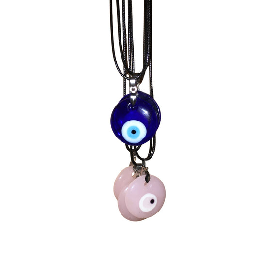 A stack of spiritual jewellery showcasing both the classic deep cobalt blue and the pastel pink glass doughnut-shaped evil eye pendant cord necklaces